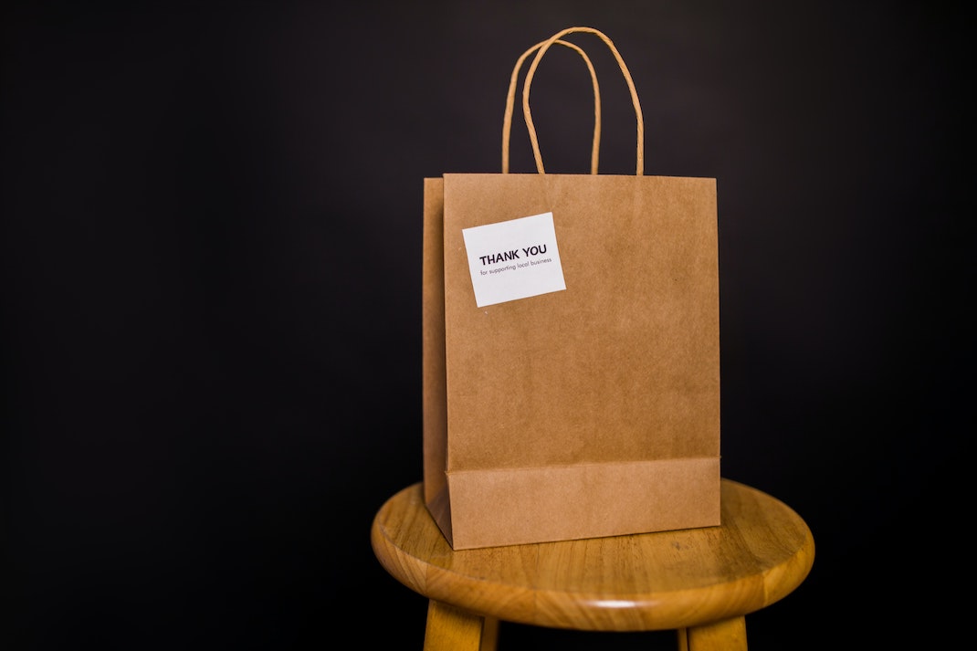 A bank with a paper bag and a note written thank you